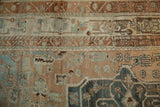 Distressed vintage Bakhtiari rug texture with white knots across copper and blue florals.
