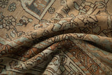 Soft folds of a distressed Baktiari carpet showing abrashed sand and powder blue floral motifs.