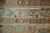 Distressed pile of a vintage Baktiari carpet with visible white knots and abrashed copper tones.