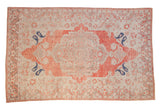 Distressed Turkish Oushak rug with a soft red medallion, silver-beige field, and bold navy botehs.