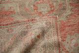 Close-up on the hand-knotted back and low pile of a distressed vintage Turkish Oushak rug.