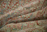 Distressed antique Sarouk carpet's soft, evenly worn pile and muted pomegranate-slate floral motifs.