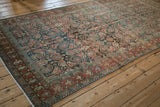 The rich, time-softened Herati pattern on a vintage distressed Hamadan runner, viewed at an angle.