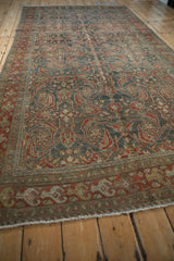 Perspective view of a vintage Hamadan runner, showing the even wear across its allover Herati design.