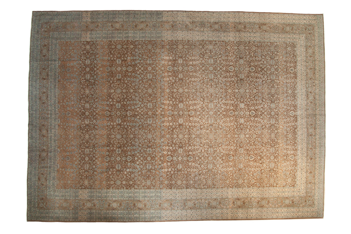 Distressed vintage Hereke carpet with coffee brown field, pale blue floral motif, and ornate arabesque border.