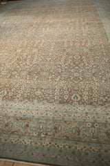 Distressed Hereke carpet border with arabesque and roundel motifs; soft blue and brown tones.