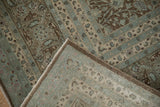 Folded corner of vintage distressed Hereke carpet, showing floral pile, white knots, and woven foundation.