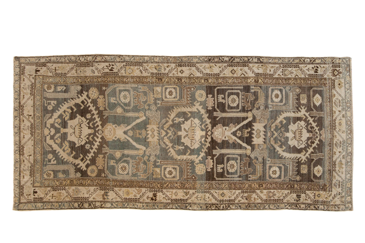 Vintage distressed Hamadan runner with a unidirectional field of animal motifs in faded teal and sand.