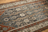 Distressed pile of a vintage Hamadan runner with interconnected vines in charcoal, silver, and rust.