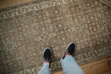 Mostly even wear and coffee brown abrashes on a distressed vintage Hamadan runner with a Herati motif.