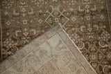 Corner of the distressed Hamadan rug folded to reveal its detailed hand-knotted foundation.