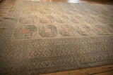 Angled view of a vintage Ersari carpet highlighting its repeating elephant footprint gul design.
