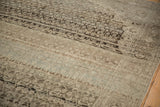 Angled view of heavy color abrashes across the distressed, low-pile texture of a vintage Bijar.