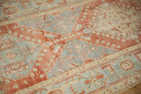 Time-worn texture of a vintage Heriz runner with geometric patterns in faded red and powder blue.