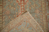 A folded corner of the vintage Heriz runner reveals its hand-knotted back and low pile.