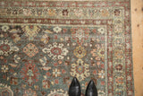 Angled view of a vintage Mahal runner's distressed texture, showing pomegranate motifs and floral borders.