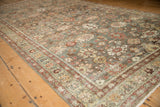 Angled detail of the distressed Mahal rug's floral field and madder red border.