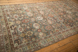 Angled view of a distressed Mahal runner's silver field with red floral patterns.