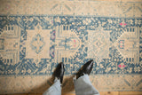Geometric motifs in dusty teal and ivory with fuchsia accents on a distressed Persian rug runner.