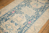 Evenly worn pile on a vintage Persian runner showing geometric teal and fuchsia motifs.