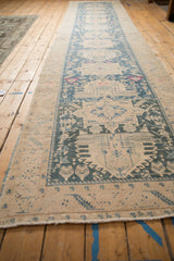 A long perspective view of the vintage distressed Persian runner's geometric medallion column.