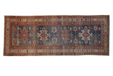Vintage distressed Malayer runner with repeating geometric medallions in indigo blue and pomegranate red.