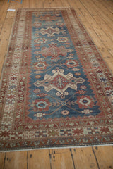 Perspective view of a vintage runner with an abrashed indigo ground and red geometric medallions.