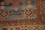 Close-up of the ram's horn motifs and crab-style border on a distressed Malayer rug runner.