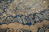 Detail of Rococo style roundels and millefleur patterns on a navy and beige Kerman carpet.