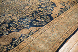 Ornate Samovar elements bordering the navy floral field of a vintage Persian Kerman carpet.