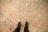 Distressed low pile on a vintage Ahar carpet with sand, dusty blue, and pomegranate red accents.