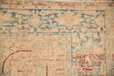 Corner detail of a vintage Ahar carpet showing even wear on sand and blue patterns.