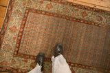A top-down view of a distressed Bijar runner with repeating rust and teal botehs.