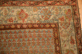 Close-up of a vintage Bijar corner showing the Serbend-style vine border and repeating boteh field.