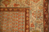 Vintage Bijar runner corner showing the boteh field alongside its rust-colored Serbend-style border.