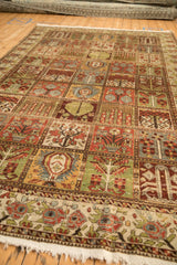 Low angle view of a distressed Bakhtiari carpet's colorful garden panels and time-softened texture.