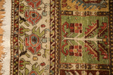Distressed Bakhtiari carpet edge showing the intact selvage, worn texture, and green paneled design.