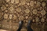 Textured low pile of a distressed antique Bijar runner with palmette designs on a chocolate brown field.