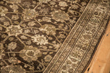 Intricate palmette designs on the time-softened, low pile of a chocolate brown antique Bijar rug.