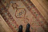 Close-up of the seeded lattice field and central geometric medallion on an antique Persian runner.