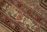 Detailed view of the antique runner's border, showing meandering blossoms and checkered relief motifs.