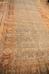 Angled view of a distressed Bijar runner highlighting time-softened abrashes in blue and terracotta.