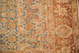 Corner view of a distressed Bijar runner showing its Herati-patterned field and wide floral border.