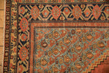 Corner of an antique Malayer showing the boteh spandrel and geometric pomegranate border motifs.