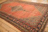 Antique Persian Malayer carpet viewed at an angle, revealing subtle shadow designs on its madder root field.