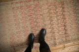 Decorative wear across the dusty ruby red boteh design of this antique Persian Malayer runner.
