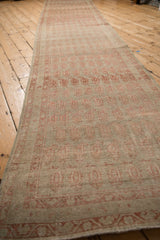Perspective shot emphasizing the length and worn texture of the antique Malayer runner.