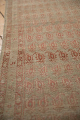 Angled view of an antique Malayer runner showing the low pile, boteh design, and intact side selvage.