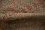 A rolled section of the antique Malayer runner reveals its textured, worn pile and boteh motifs.
