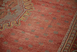 Low pile and even wear on a vintage Oushak's pomegranate red field with slate blue starburst motifs.